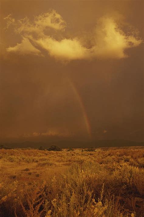 A Rainbow Appears In Storm Clouds Photograph by Paul Damien