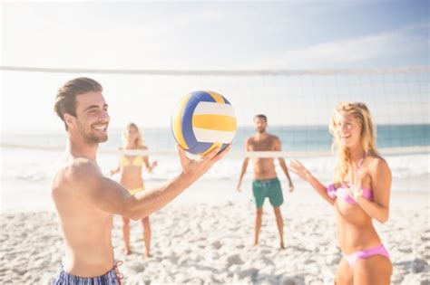 Premium Photo | Friends playing beach volleyball