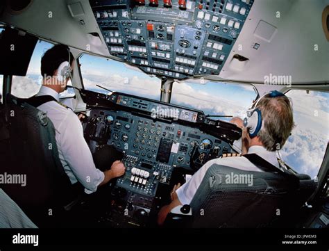 pilots wearing headsets in the cockpit of a BAE 146 flying Stock Photo ...