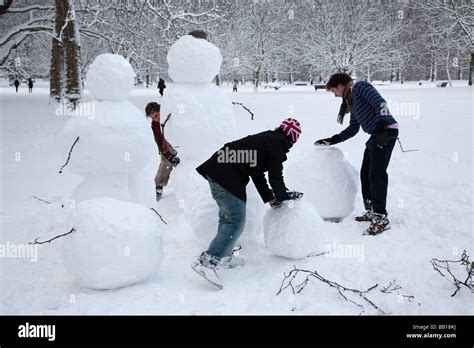 People making snowman family Stock Photo - Alamy