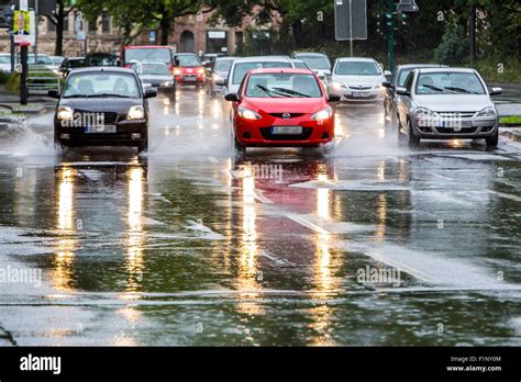 Cars driving in heavy rain weather, wet surface of the street ...