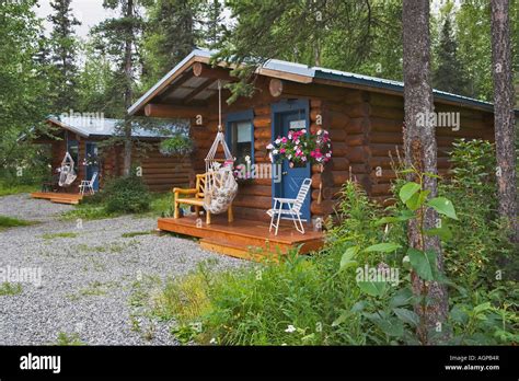 USA, Alaska, Palmer. Log cabins nestled among trees near Hatcher Pass ...