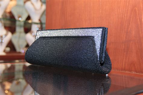 Stylish Black Pearl clutch finished with silver zircons studs. For more ...