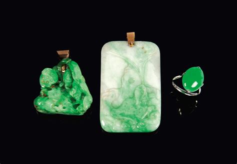 TWO CHINESE APPLE GREEN JADEITE PENDANTS AND ONE JADEITE PLAQUE MOUNTED ...