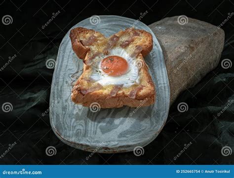 Homemade Fried Egg in a Hole Bacon and Cheese Toast on Ceramic Tray with Dark Background Stock ...