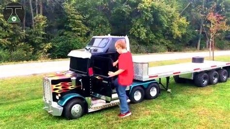 a man standing next to a semi truck with flames on it's flatbed