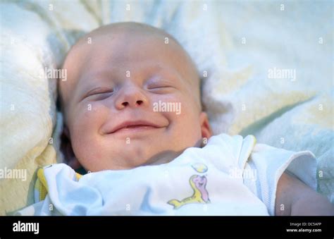 Baby smiling while sleeping Stock Photo - Alamy