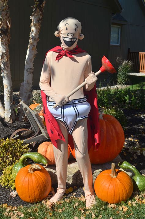 a statue of a man with a hammer in front of some pumpkins and trees