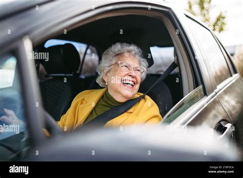 Happy senior woman driving car alone, enjoying car ride. Safe driving for elderly adults, older ...