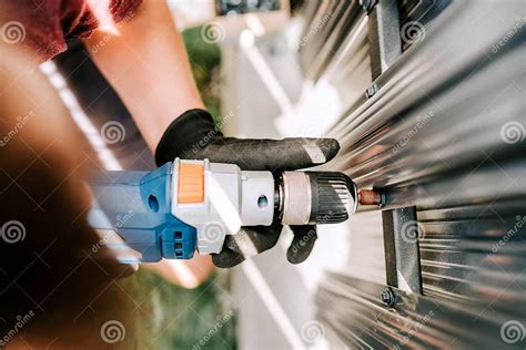 Worker Using Electrical Cord Screwdriver for Fastening Screws into Metal Fence Stock Photo ...