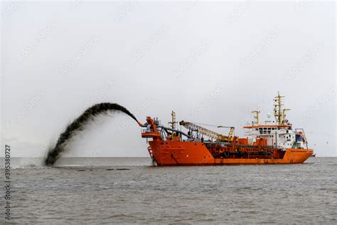 Vessel engaged in dredging. Dredger working at sea. Ship excavating material from a water ...