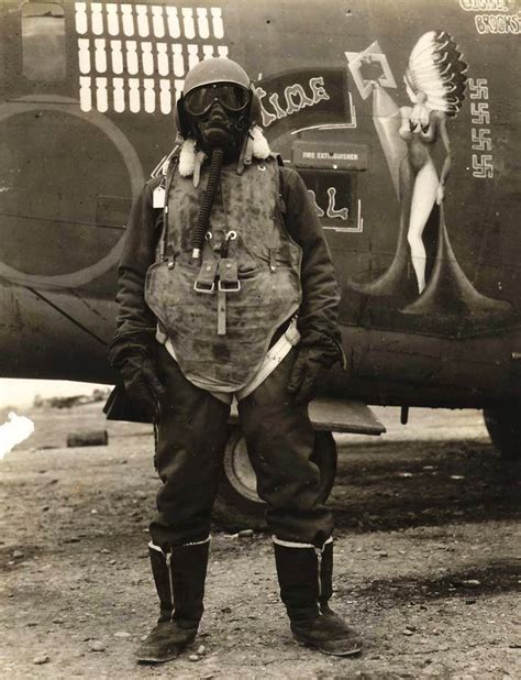 An airgunner stands before his B-24 bomber wearing what it took to survive at 25,000ft altitude ...