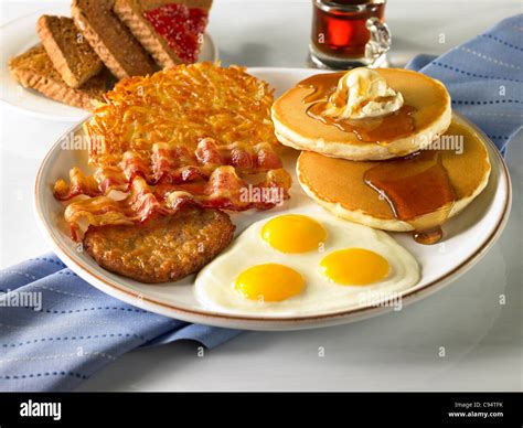 A power breakfast with three eggs, sausage, bacon, hash browns, pancakes with butter and syrup ...