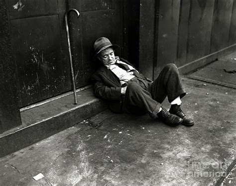 Homeless Man Sleeping On A Sidewalk by Bettmann