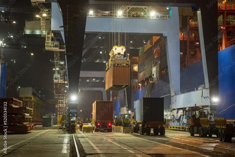 operation of container terminal at night. Unloading container ship at ...