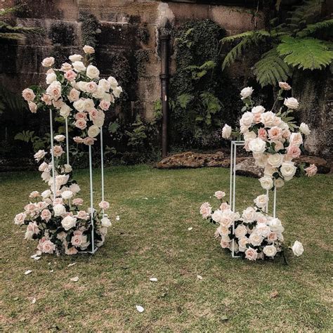 three metal planters with flowers on them in the grass