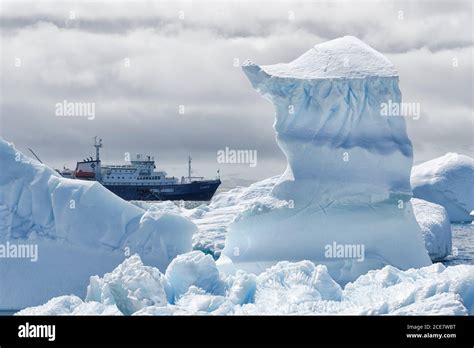 View between two snow peaks to a small cruise ship, Antarctic Peninsula ...