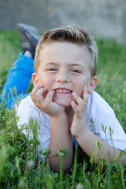 Premium Photo | Pensive kid lying on the grass