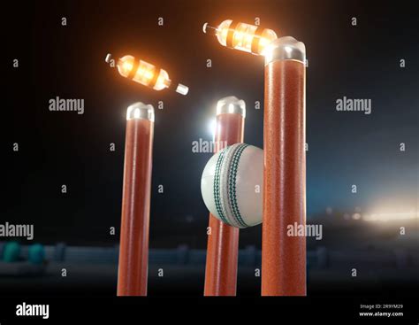 A white cricket ball striking orange electronic cricket wickets with ...