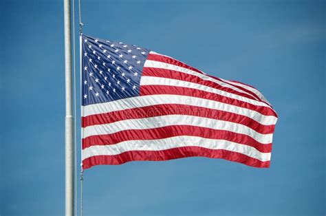 American Flag Flying at Half Mast Against Blue Sky Stock Photo - Image ...