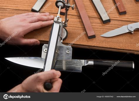 Hands sharpening a Japanese knife with Damascus steel using a manual machine Stock Photo by ...