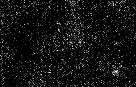 black and white photograph of snow flecks in the night sky with no clouds