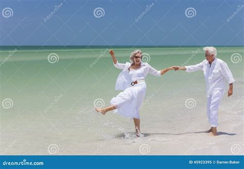 Happy Senior Couple Dancing Holding Hands on a Tropical Beach Stock ...