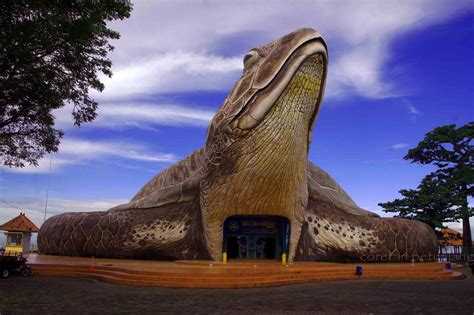 a giant turtle statue sitting in front of a building