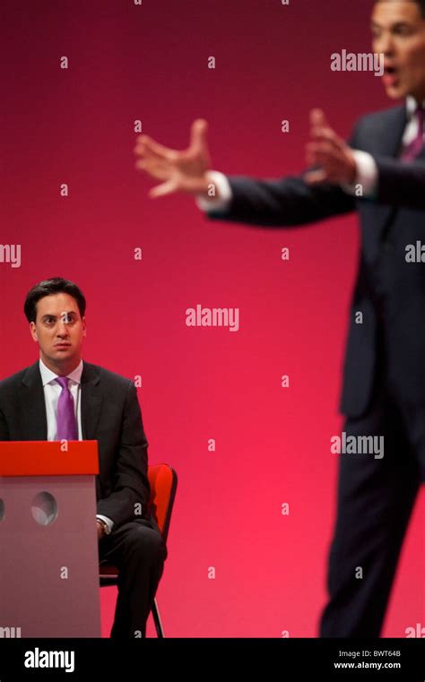 As newly elected Labour leader and younger brother, Ed Miliband, looks on David Miliband ...