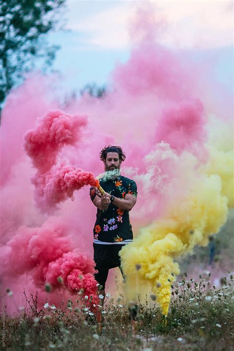 "Fashionable Hipster Man Holding Colorful Smoke Bombs In Nature" by ...