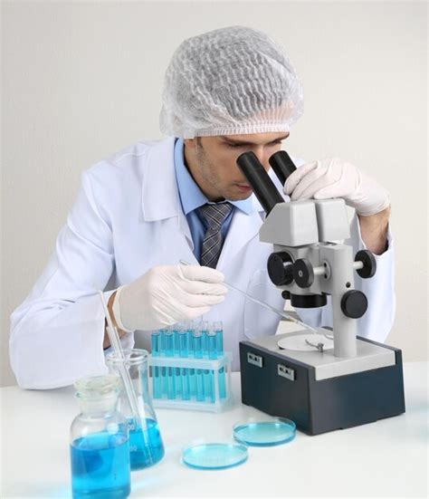 Premium Photo | Young laboratory scientist looking at microscope in lab