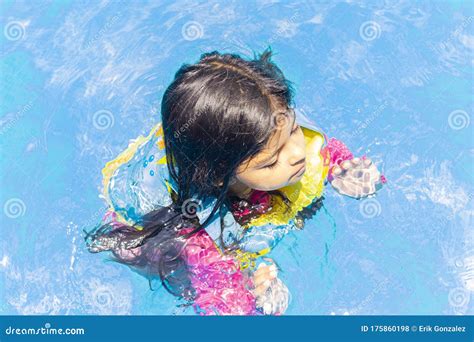 Little Girl Swimming with Floaties, in the Blue Waters of a Pool Stock ...