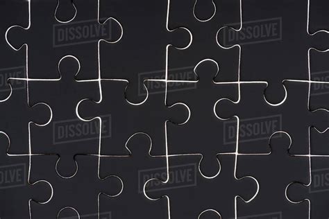 Full frame of black puzzle pieces background - Stock Photo - Dissolve