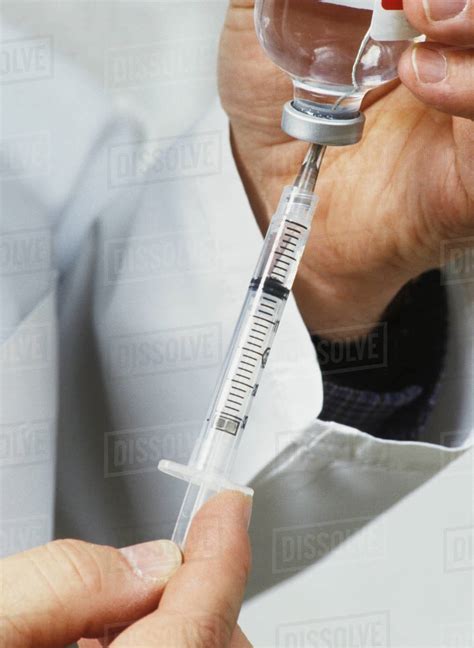 Medical Personnel Drawing Injection From Vial - Stock Photo - Dissolve