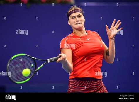 Aryna Sabalenka of Belarus returns a shot to Ashleigh Barty of Australia in their group match ...