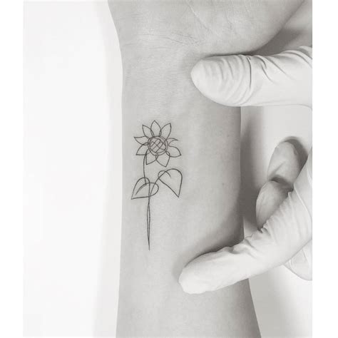 One line sunflower tattoo located on the wrist.