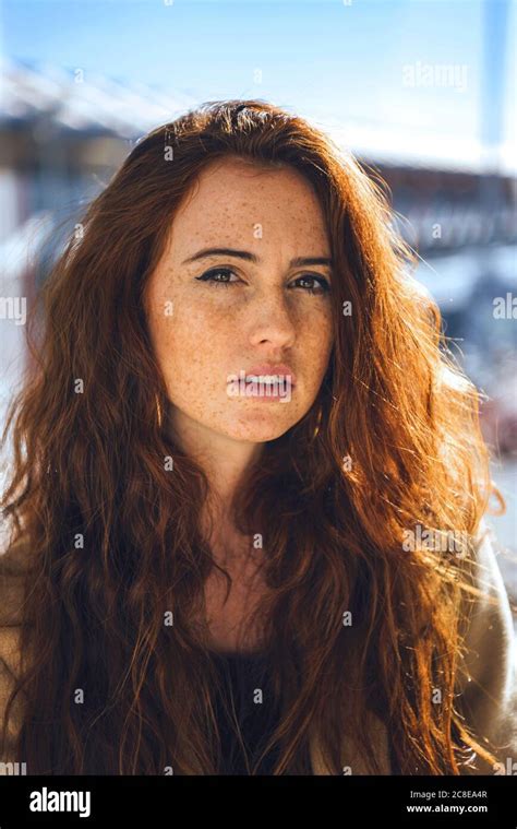 Confident woman with freckles on face during sunny day Stock Photo - Alamy