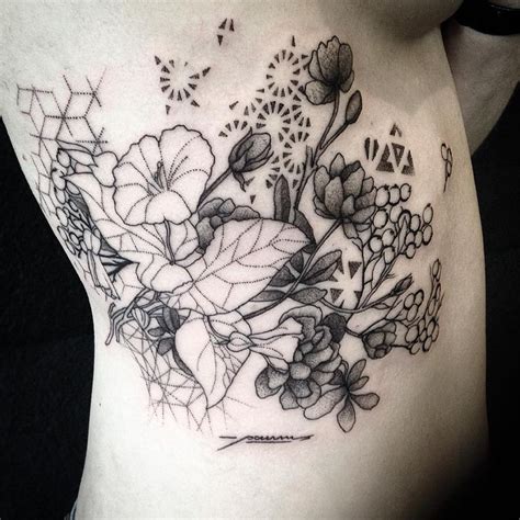 a woman's stomach with flowers and butterflies on it in black and grey ink