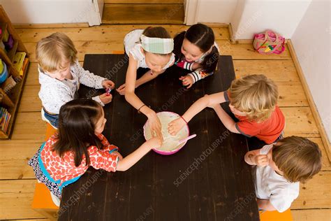 Children sharing food in kitchen - Stock Image - F005/3331 - Science Photo Library