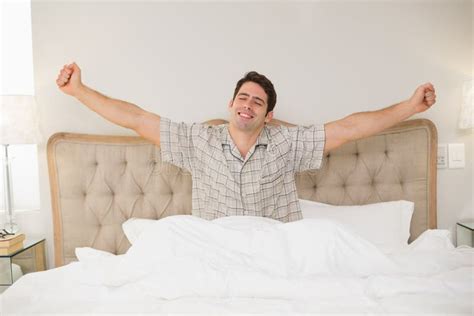 Young Man Waking Up in Bed and Stretching His Arms Stock Image - Image ...