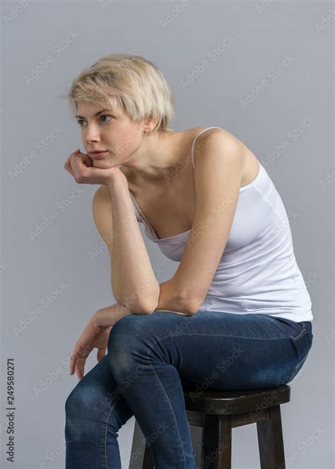 Girl on chair snap, thinking pose holding chin Stock Photo | Adobe Stock