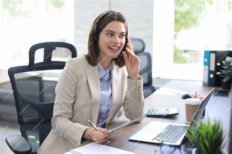 Premium Photo | Cheerful female manager sitting at office desk and ...