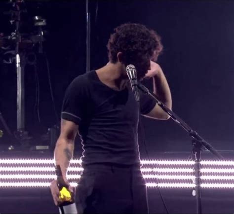 a man standing next to a microphone on top of a stage