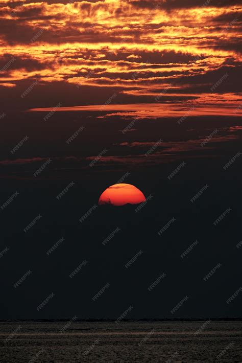 Premium Photo | Orange sunset with red fire clouds by horizon