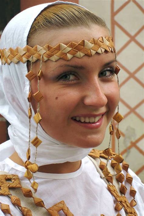 a woman wearing a head piece with braids on it's hair and smiling