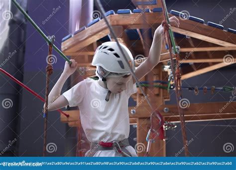 A Teenager Goes through an Obstacle Course on a Rope Ride in Safety ...