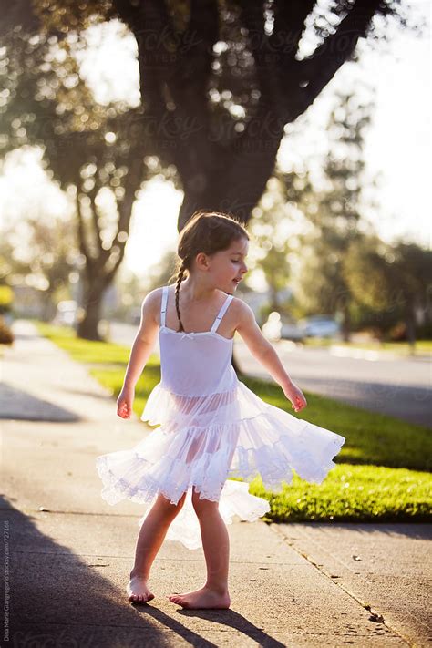 Young Girl Wearing White Slip Dress Twirling On Sidewalk by Dina Marie ...