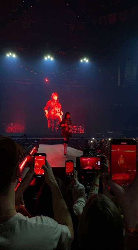 people holding up their cell phones in front of an audience at a ...