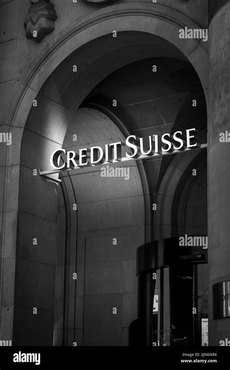 A vertical shot of black and white Credit Suisse logo above building ...