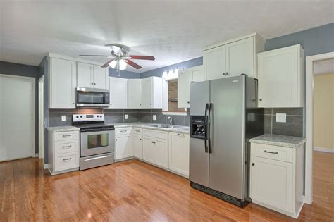 Brand new kitchen with white cabinets, stainless steel appliances, tile backsplash make this ...